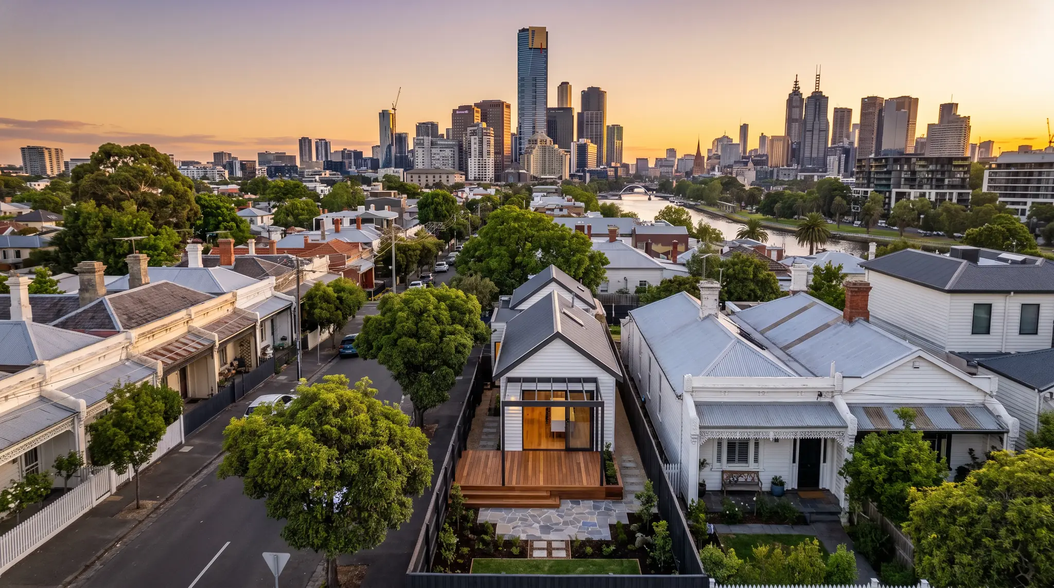 Melbourne terrace houses with a newly landscaped backyard and deck, the CBD skyline beyond