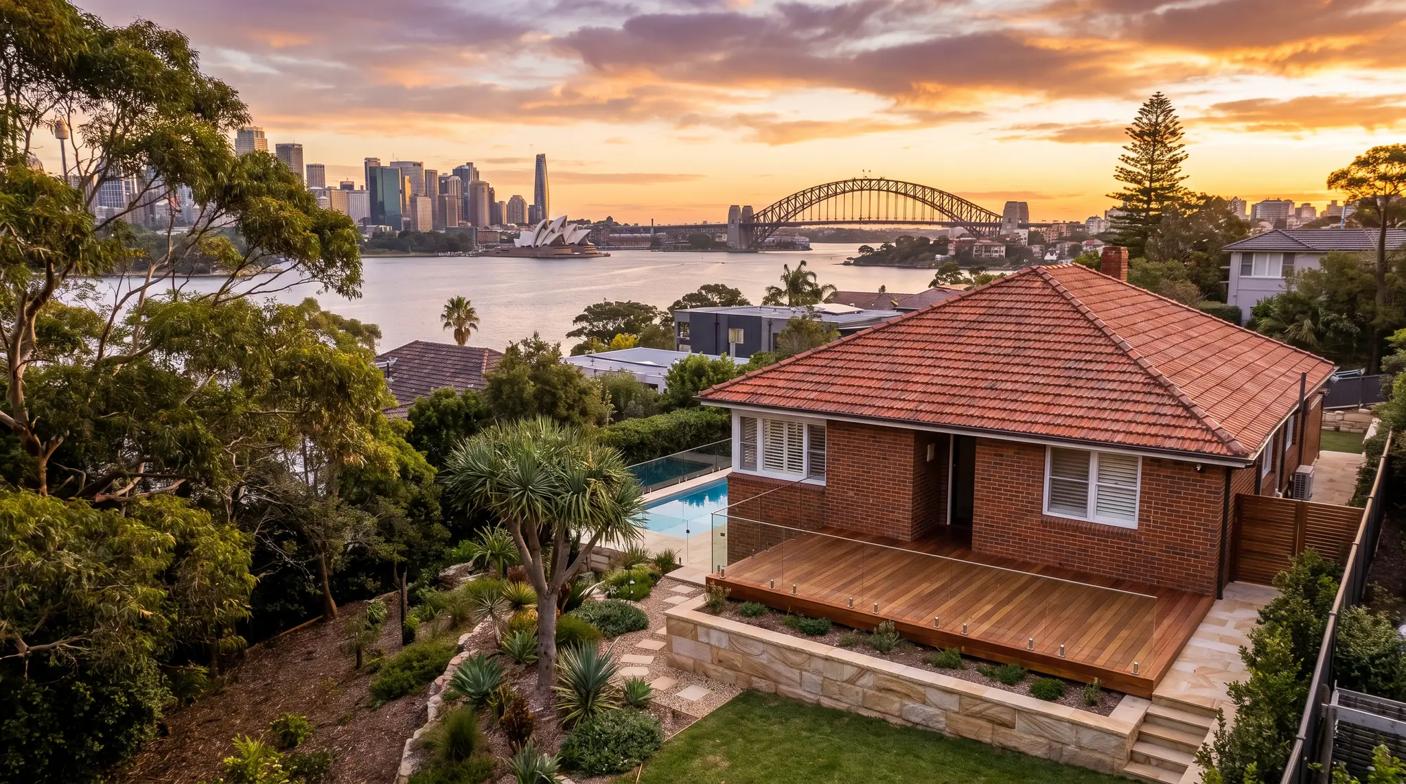 A harbourside Sydney home with a new deck and sandstone walls, the Harbour Bridge and Opera House beyond